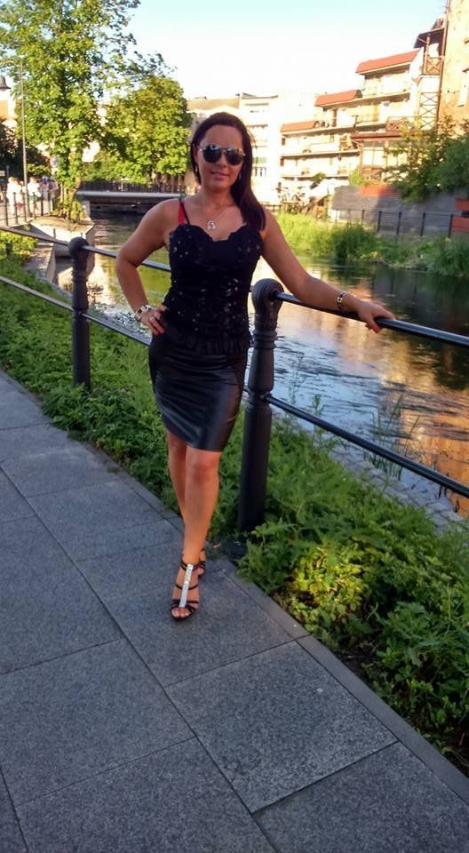 Tanned chick in leather dress outdoors