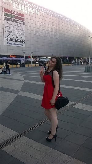 Nice brunette in sexy red mini dress and black high heeled sandals