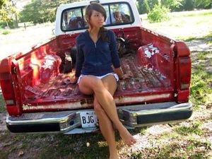 Country Girl with legs hanging out the old ford