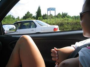 Pinching her nice tits in the car