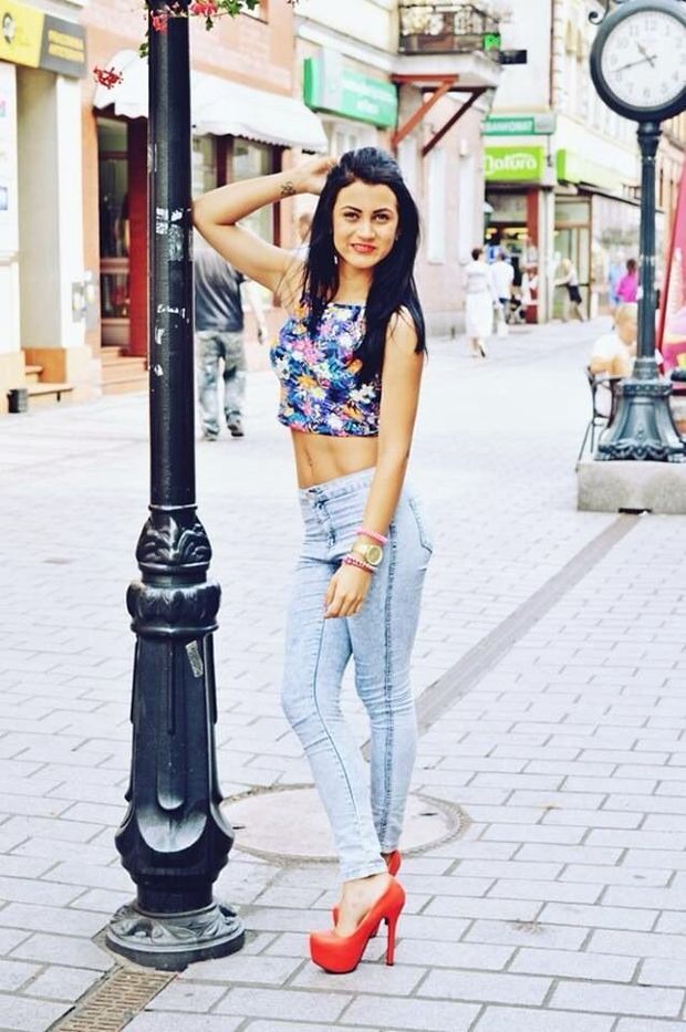 Slim babe posing on the street in tight jeans and red heels
