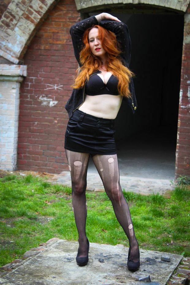Unusual but tempting outfit during the photosession of a red-hair model