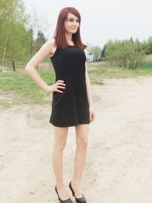 Redhead in simply mini black dress outdoors