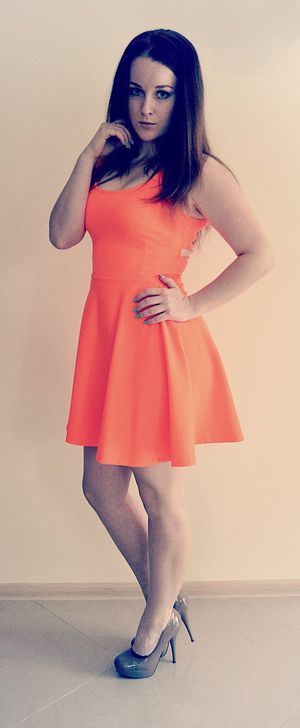 Sexy brunette posing in oragne dress