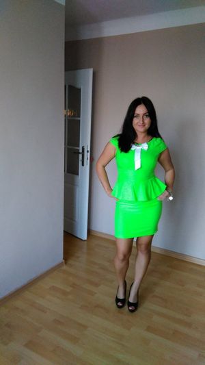 Charming sexy brunette in tight green outfit at home
