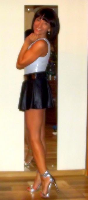 Leggy sexy milf in micro leather skirt and high heeled sandals at home