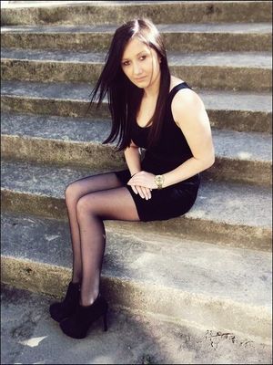 Black hair chick in tight mini black dress, ankle boots and pantyhose