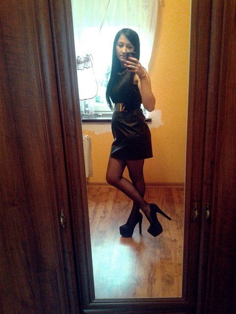 Brunette posing in leather black dress