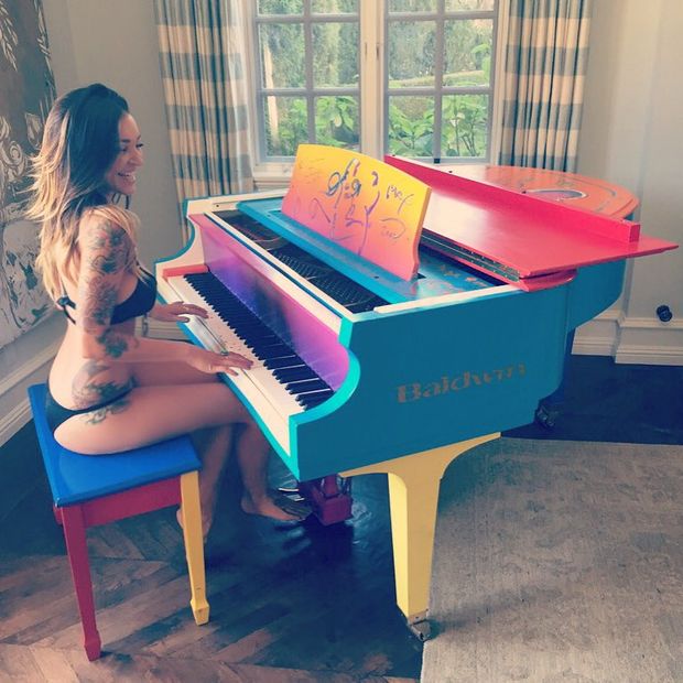Hot tattooed babe playing piano