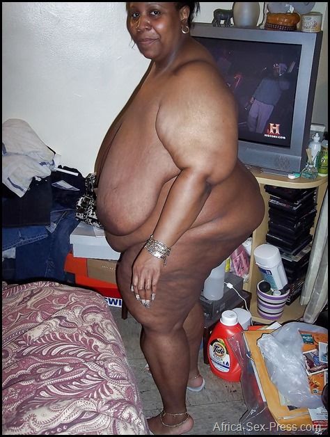 Big African Old Mama with Enormous Breast Big Flaccid Belly and Flip Flops Ready for the Client on Her Shabby Hovel
