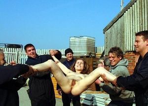 Naked, legs spread and held by clothed men....