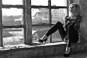 Lace blouse on beautiful blonde model posing in some abandoned building