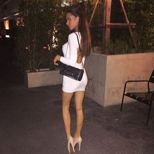 Horny chick, bra and pantyless in tight, mini white dress with nice back cleveage