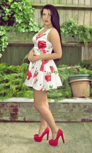 Cool brunette in a loose floral dress and red high heels