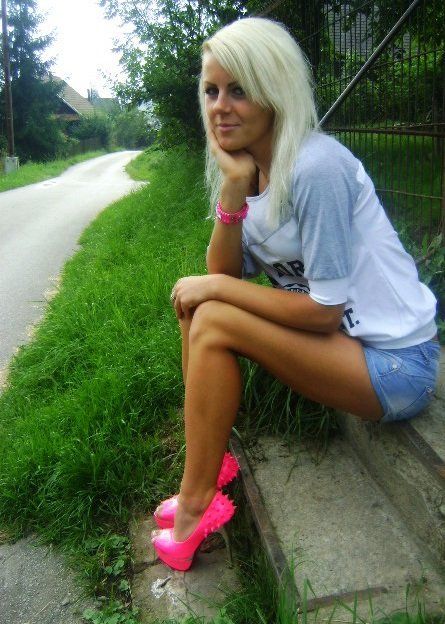 Country chick in neon-pink high heels outdoors