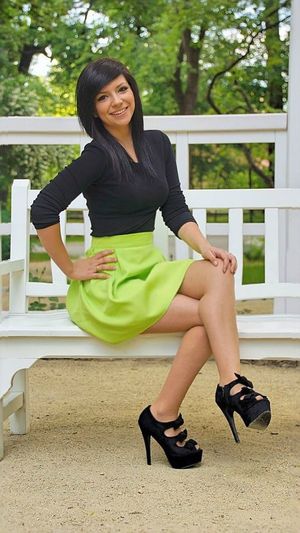 Leggy brunette in nice skirt and high heels posing outdoors