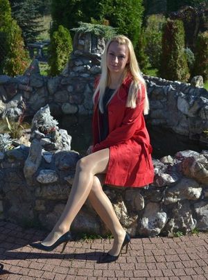 Leggy blonde in shiny nylons and black stilettos outdoors