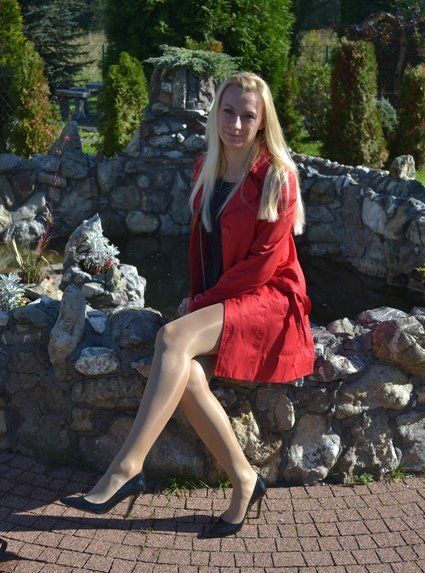 Leggy blonde in shiny nylons and black stilettos outdoors