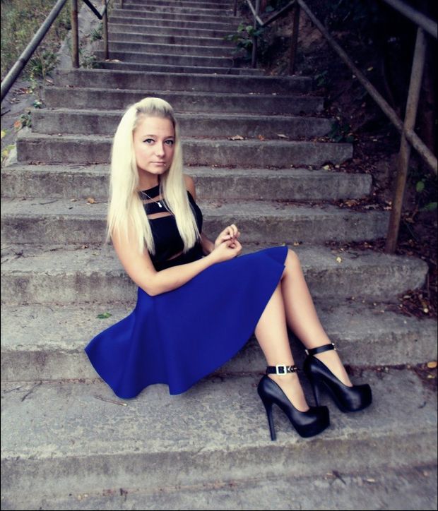 Blonde babe posing outdoors on the stairs in nice blue skirt and really high black heels