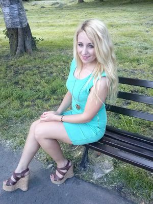 Cute blonde on a park bench in hight wedges and tight mini dress