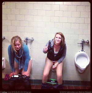 Two women peeing in the mens room
