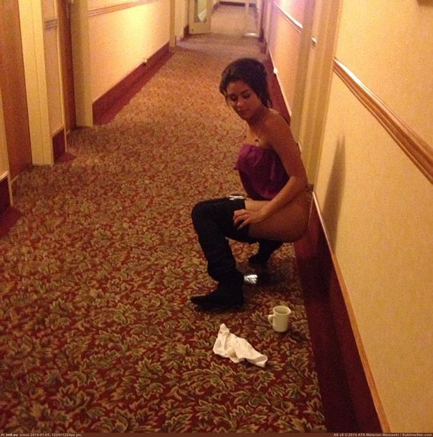 Teen peeing in a hotel hallway