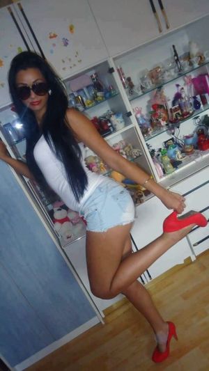 Tanned dark hair bimbo in red heels