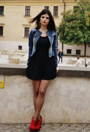 Sexy brunette posing outdoors in mini dress and red heeled ankle boots