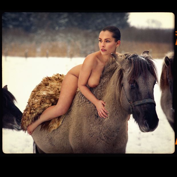 Brunette riding a horse naked