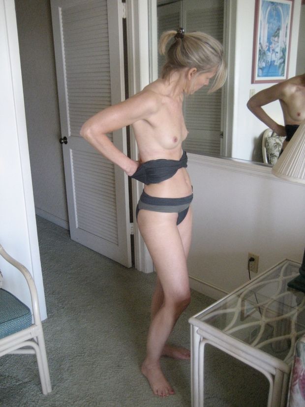 Petite blonde in black lingere getting ready