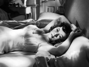 PIC - Gloria Grahame reclining on a bed.