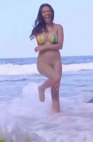 Hot bikini clad woman jumping on the beach