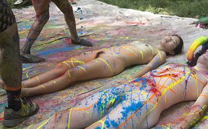Another photo of the beautiful asian getting painted, fully nude, and lying there, her sexy bush exposed