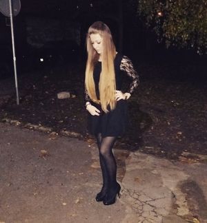 Long hair blonde posing outdoors in black mini dress