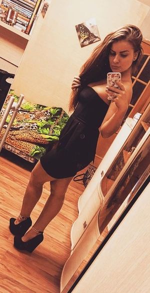 Sexy brunette in tight black mini dress and wedges