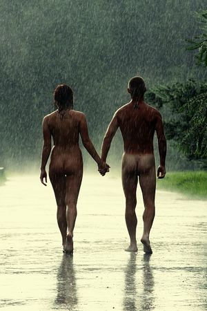 romantic athletic couple walks nude in the rain