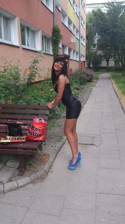 Tanned chick in black mini dress and blue pumps on the hood