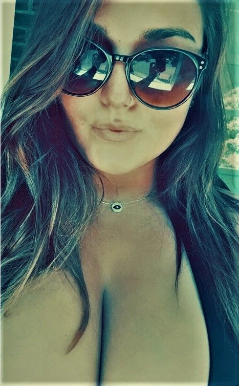 Busty amateur taking a selfie of her cleavage