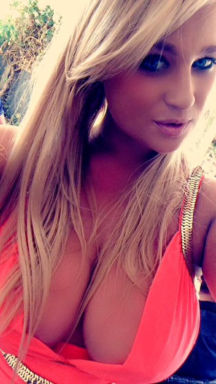 Hot amateur blonde shows off her lovely cleavage in low cut dress