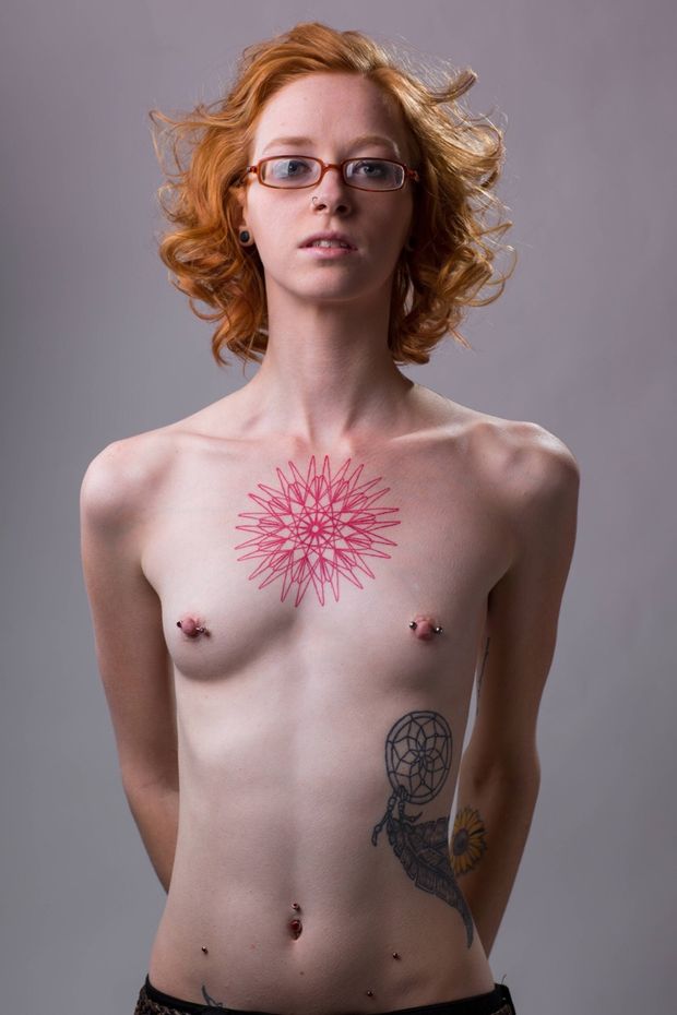 Slender redhead with tattoos and piercings