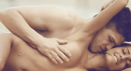 Rubbing and grabbing her breast while spooning