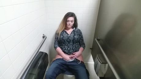 Chubby babe is masturbating like crazy in a public toilet