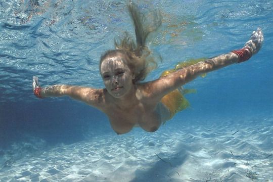 Swimming naked underwater.