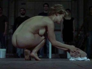 Nude squatting to put away the last of her clotes