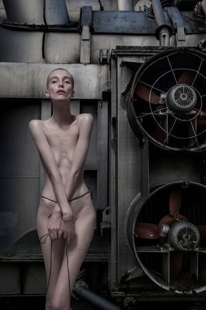 Bardzo chuda naga modelka w industrialnej scenerii