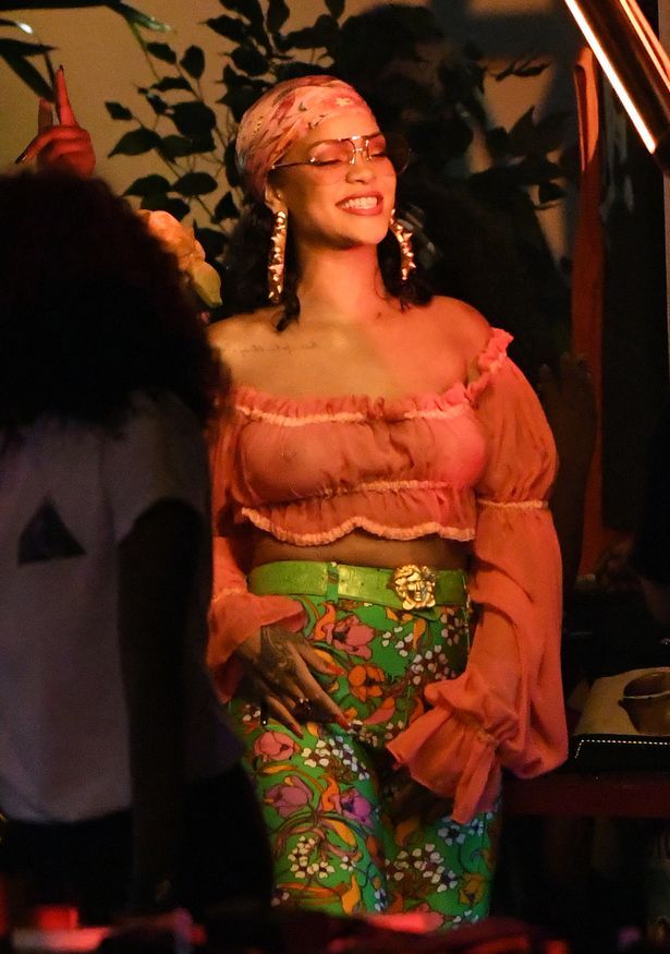 Rihanna shows her boobs in a see through top.