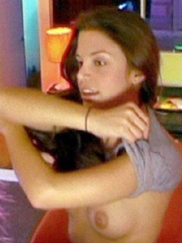 Vanessa Ferlito pulling off her shirt, showing a boob.
