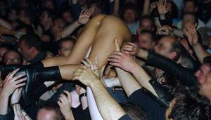 Rockbitch member crowdsurfing naked at a show.