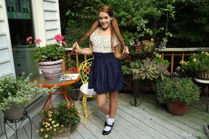 Redhead with extreme long pigtails in the garden