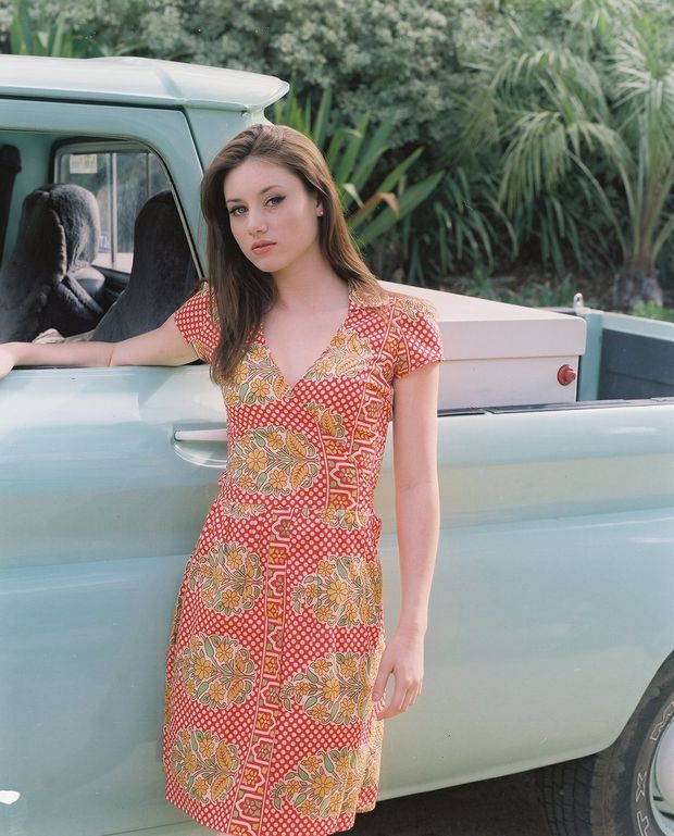 Pretty brunette farmer's daughter standing next to truck